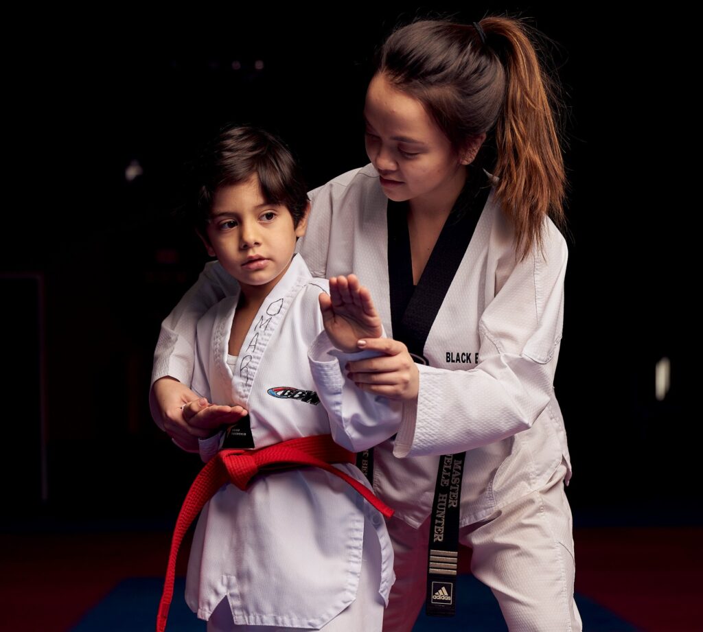 Young students practicing high kicks in a karate for kids class to build confidence and discipline.